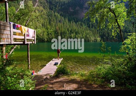 Frau Fische aus dem Dock einer Kabine am Echo Lake Resort in der Nähe von Vernon in der Okanagan Region von British Columbia, Kanada. MR022. Stockfoto