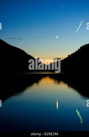 Meteor schießt über den Himmel in der Abenddämmerung über Echo Lake Resort in der Nähe von Vernon in der Okanagan Region von British Columbia, Kanada Stockfoto