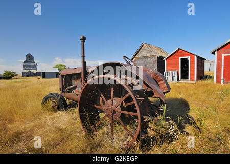 Alten Traktor, Schuppen und Getreidesilo in Geisterstadt Fusiller Saskatchewan Kanada Stockfoto