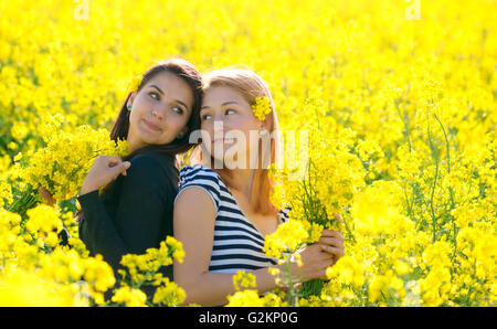 zwei Beautiul Mädchen, die Spaß im Feld Raps Stockfoto