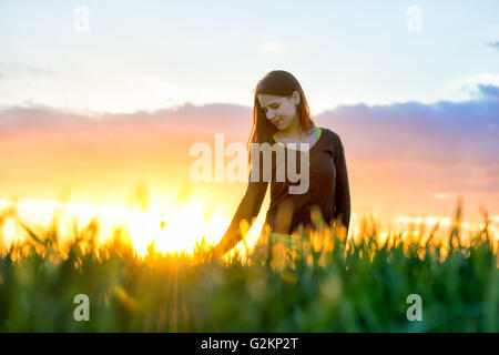 Schönheit Mädchen im Freien genießen Natur. Schöne Teenager-Model Mädchen im weißen Kleid läuft auf dem Feld, Sonnenlicht. Leuchten der Sonne Stockfoto