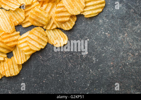 Runzeln Sie geschnittene Kartoffel-Chips am Tisch. Lecker würzig Kartoffelchips. Stockfoto