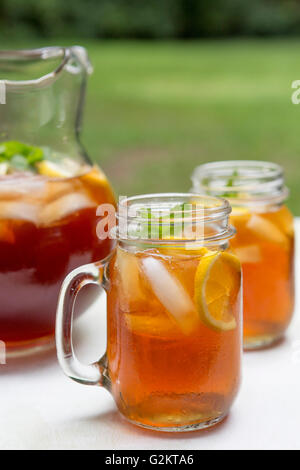 Eistee im Krug und Glas Becher mit Zitrone und Minze Stockfoto