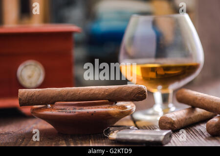 Zigarren und Cognac mit Humidor im Hintergrund auf Holztisch Stockfoto