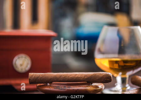 Zigarren und Cognac mit Humidor im Hintergrund auf Holztisch Stockfoto