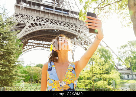 Paris, Frau tut ein Selbstporträt mit Eiffelturm auf Hintergrund Stockfoto