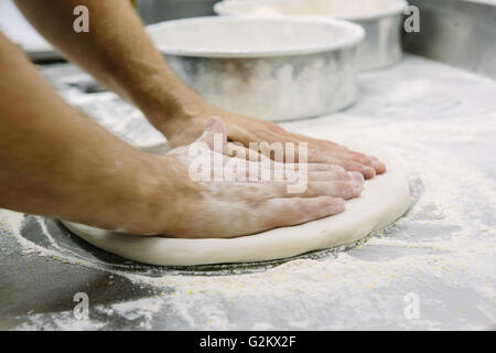 Bakers Hände Abflachung Teig Stockfoto