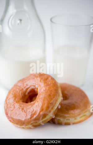 Zwei verglaste Krapfen mit Milch Stockfoto