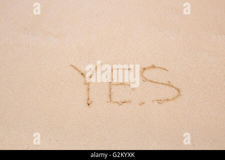 Ja - geschrieben im Sand am Strand Textur Stockfoto