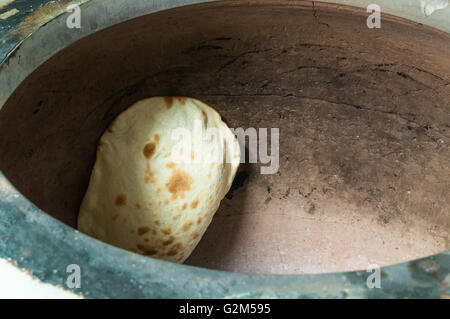 Traditionelle Naan-Brot dabei, in einem Lehmofen backen. Stockfoto