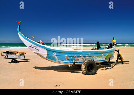 Portugal: Traditionelle bunte Fischerboote im Sand des Strandes Praia da Vieira Stockfoto