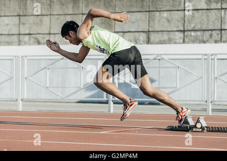 männlicher Athlet beginnt von Startblöcken auf einer Strecke von 400 Metern während UrFO Meisterschaft in der Leichtathletik Stockfoto