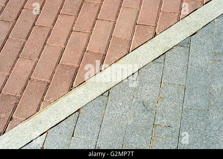 Rote und graue Pflaster Backsteine von weißem Beton getrennt. Stockfoto