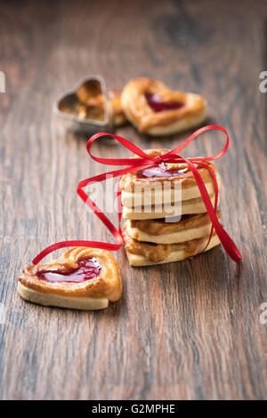Frische Kekse mit einem Bogen auf einem Holztisch. Verwenden Sie es für eine Karte oder ein Rezept.