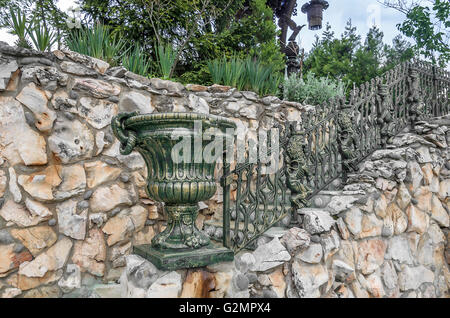 Dekorative Vase im Garten auf einem Hintergrund von Grün. Stockfoto