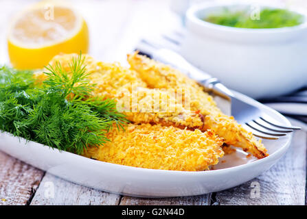 Gebratener Fisch auf Teller und auf einem Tisch Stockfoto