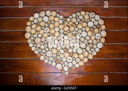 Herzform an der Wand aus Holz Rundstangen Stockfoto