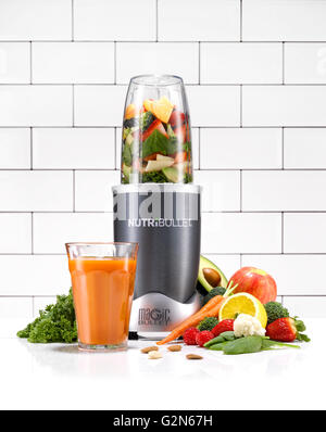 Ein Nutribullet in einer Kücheumgebung umgeben von gesundes Obst und Gemüse. Stockfoto