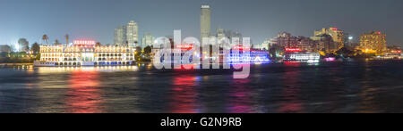 Panoramablick auf der Insel Zamalek im Zentrum von Kairo bei Nacht mit seiner berühmten Boot Restaurants auf dem Nil. Stockfoto