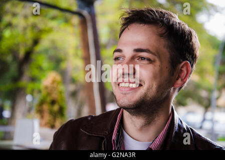 Junge attraktive fröhliches Mädchen mit langen Haaren Lächeln und posieren im Freien. Wind weht ihr Haar. Stockfoto