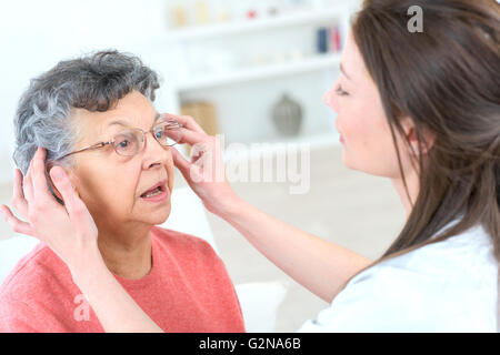 Alte Dame versucht einige Gläser Stockfoto