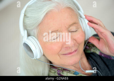 Alte Dame mit Kopfhörer auf Stockfoto