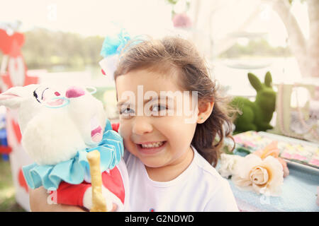 Nettes Mädchen mit Kaninchen, Alice im Wunderland-Tea-Party-Thema Stockfoto