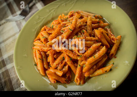 Penne Alla Wodka in rustikale Küche-Einstellung auf Teller grün Stockfoto