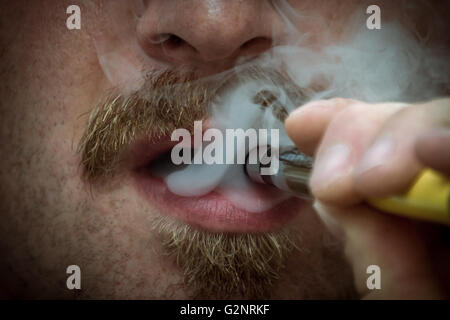 Bärtiger Mann raucht eine Vape e-Zigarette in extreme Nahaufnahme Makro Stockfoto