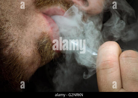 Bärtiger Mann raucht eine Vape e-Zigarette in extreme Nahaufnahme Makro Stockfoto