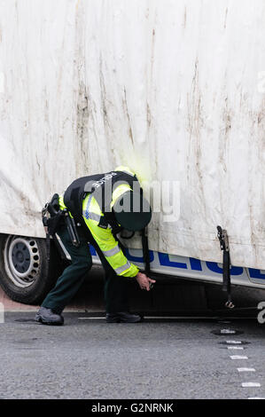 Belfast 29.09.2012 - PSNI Polizist fesselt einen mobilen Bildschirm an der Seite von einem Polizei-Fahrzeug.  Bildschirme werden in Nordirland verwendet, um die beiden Seiten der Gemeinschaft bei sensiblen Veranstaltungen wie Paraden und Demonstrationen zu trennen. Stockfoto