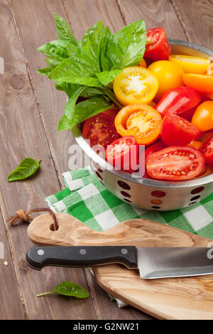 Bunte frische Tomaten und Basilikum in Sieb Stockfoto