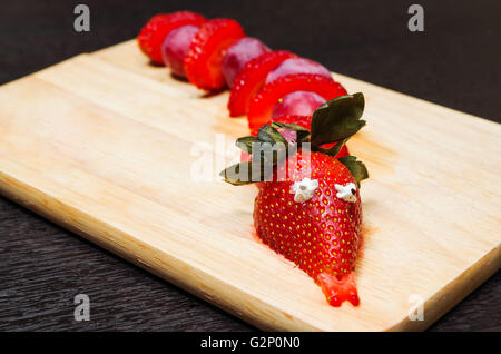 Lustig aussehende Schlange Porträt aus geschnittenen Erdbeeren und Trauben hergestellt Stockfoto