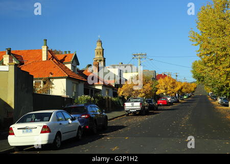 Autos auf einer Straße in Battery Point mit Str. Georges anglikanische Kirche im Hintergrund - Hobart, Tasmanien, Australien. Stockfoto