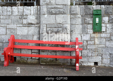 rote Bank gegen eine Wand in Cobh Grafschaft cork Irland Stockfoto
