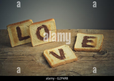 Toastbrot mit dem Wort Liebe gemalt mit Haselnuss Schokolade Verbreitung Stockfoto