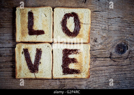 Toastbrot mit dem Wort Liebe gemalt mit Haselnuss Schokolade Verbreitung Stockfoto