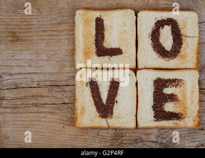 Toastbrot mit dem Wort Liebe gemalt mit Haselnuss Schokolade Verbreitung Stockfoto