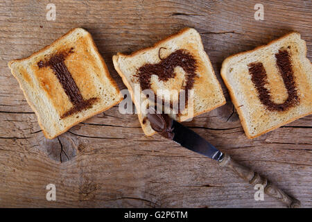 Ich liebe dich gemalt mit Haselnuss-Creme auf weißen Toast-Brot Stockfoto