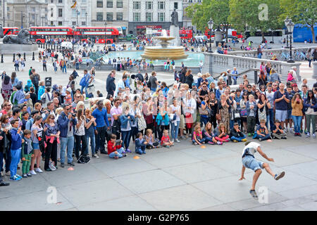 Große Schar von Menschen, die unter anderem Touristen versammeln sich um Straßenkünstler Gymnastik tanzen vor Zuschauern in Trafalgar Square London England UK Stockfoto