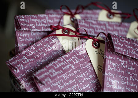 Violette Geschenktüten mit Namens-Tags auf Kinder-Geburtstagsparty Stockfoto