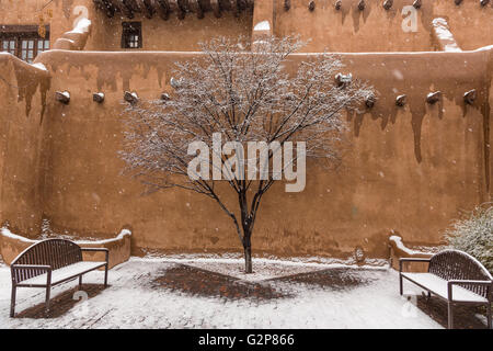 Schnee bedeckt einen Innenhof im Adobe Stil New Mexico Museum of Art im historischen Viertel 12. Dezember 2015 in Santa Fe, New Mexico. Stockfoto