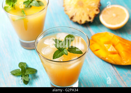 Mango-Eis-Tee mit Minze im Glas auf blauem Hintergrund aus Holz Stockfoto