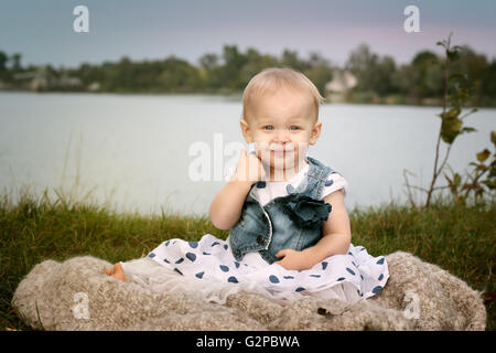 Portrait eines kleinen Mädchens an einem See mit blauen Ballon Stockfoto