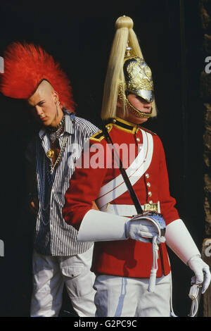 Punk Rocker Matt Belgrano, "der Herr Punk' steht mit einem Mitglied der Household Cavalry, Horse Guards Parade, London, England, UK, ca. 1980 Stockfoto