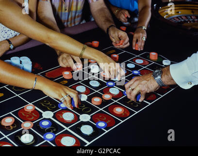 Roulette-Spieler und Händler setzen Chips auf dem Tisch Stockfoto