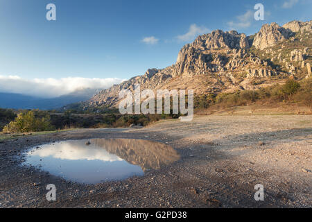 Berglandschaft mit blauem Himmel Reflexion in Pfütze bei Sonnenuntergang. Stockfoto
