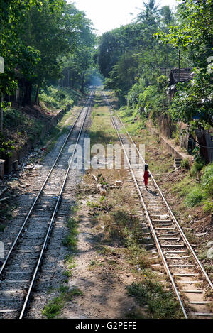 Ein junges Mädchen nach Hause auf einer zweigleisigen Eisenbahn, Yangon, Myanmar Stockfoto