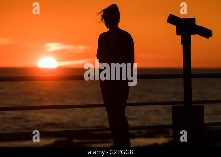 Aberystwyth Wales UK, Feiertag Mittwoch, 1. Juni 2016 UK Wetter: Eine junge Frau in der Silhouette an Aberystwyth Promenade als hinter ihr die Sonnen geht dramatisch über Cardigan Bay an der Küste bei Aberystwyth im Westen wales Küste.  Das Wetter war schön und warm an der Westküste, in scharfem Kontrast zu den Stürmen und Regen in London erlebt und östliche Regionen Bildnachweis: Keith Morris / Alamy Live News Stockfoto