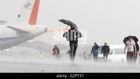 Schönefeld, Deutschland. 2. Juni 2016. Messebesucher fliehen aus einem massiven Regenguss an der Berlin Air Show (ILA) in Schönefeld, Deutschland, 2. Juni 2016. Die Airshow am Flughafen Berlin-Schönefeld ist von 01 bis 4. Juni 2016 geöffnet. Foto: WOLFGANG KUMM/Dpa/Alamy Live News Stockfoto